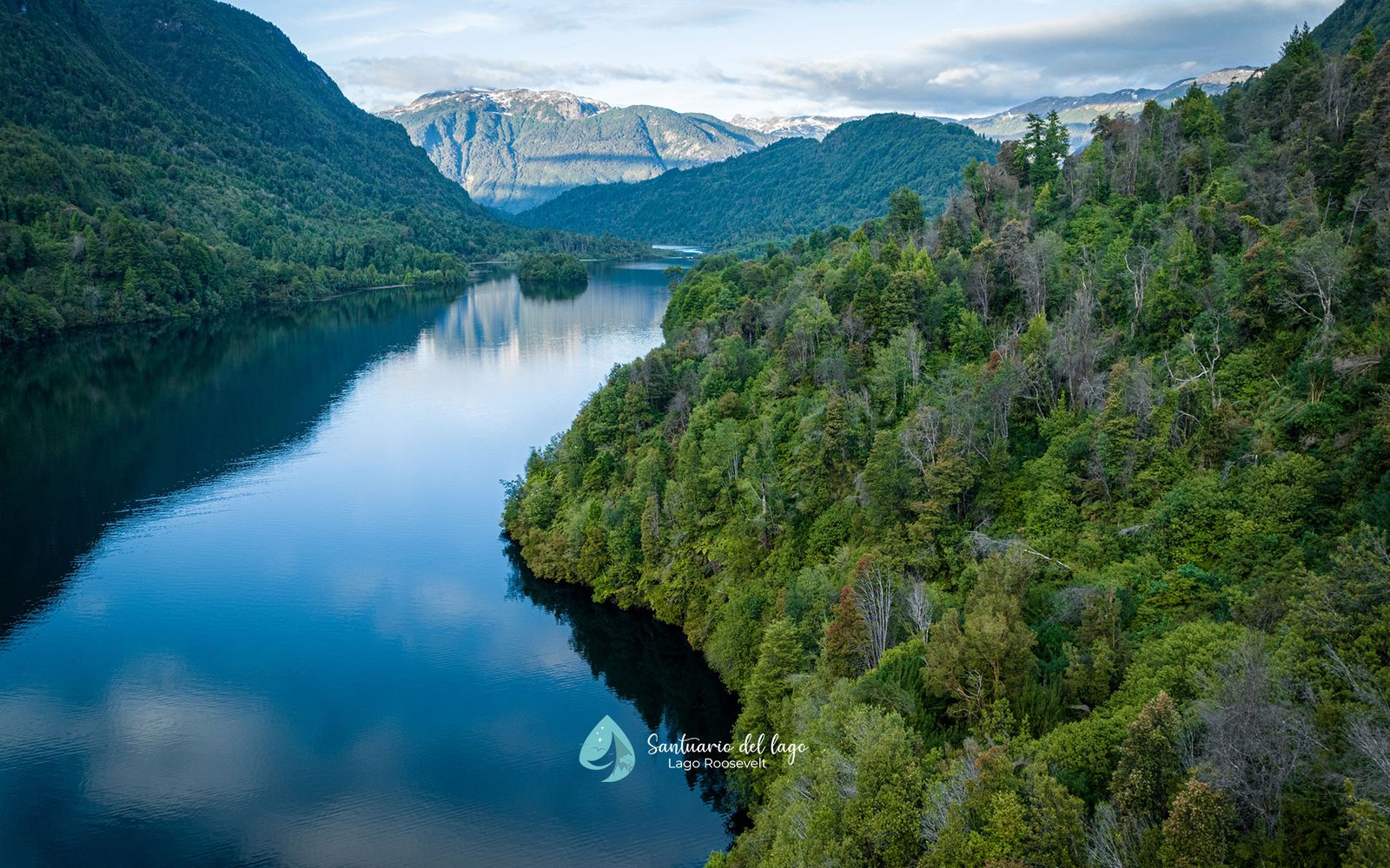 Mirror reflection of forested mountains on the lake at Santuario del Lago